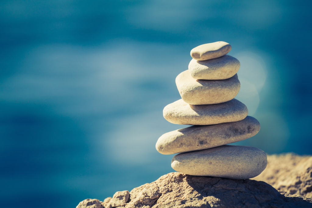 Balance and wellness retro spa concept inspiration zen-like and well being tranquil composition. Close-up of white pebbles stack over blue sea