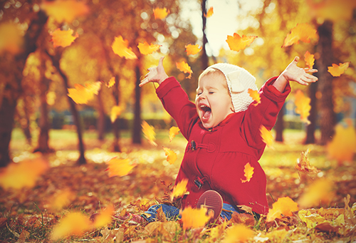 happy little child baby girl laughing and playing in the autumn on the nature walk outdoors