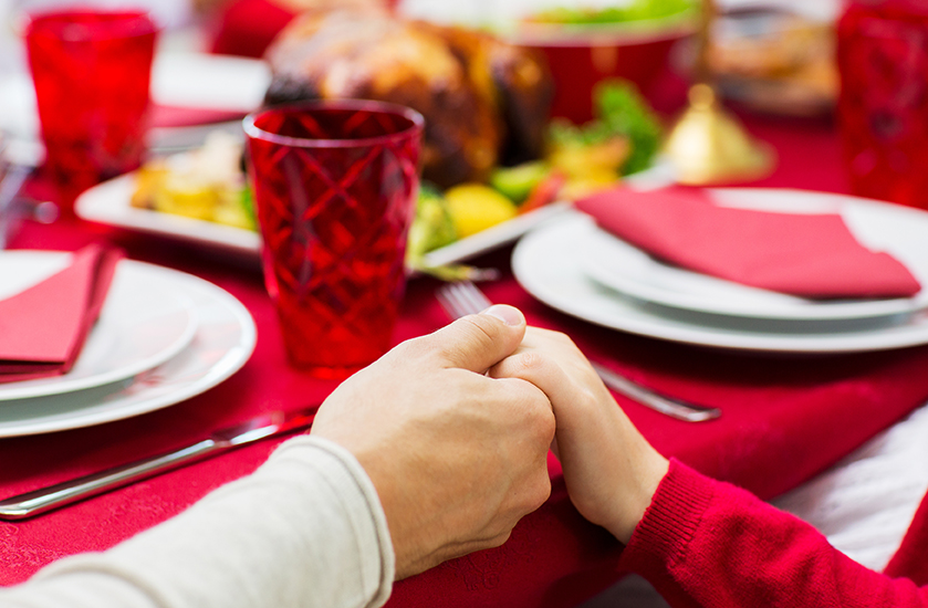 family, holiday, tradition, generation and people concept - close up of family having christmas dinner and holding hands at home